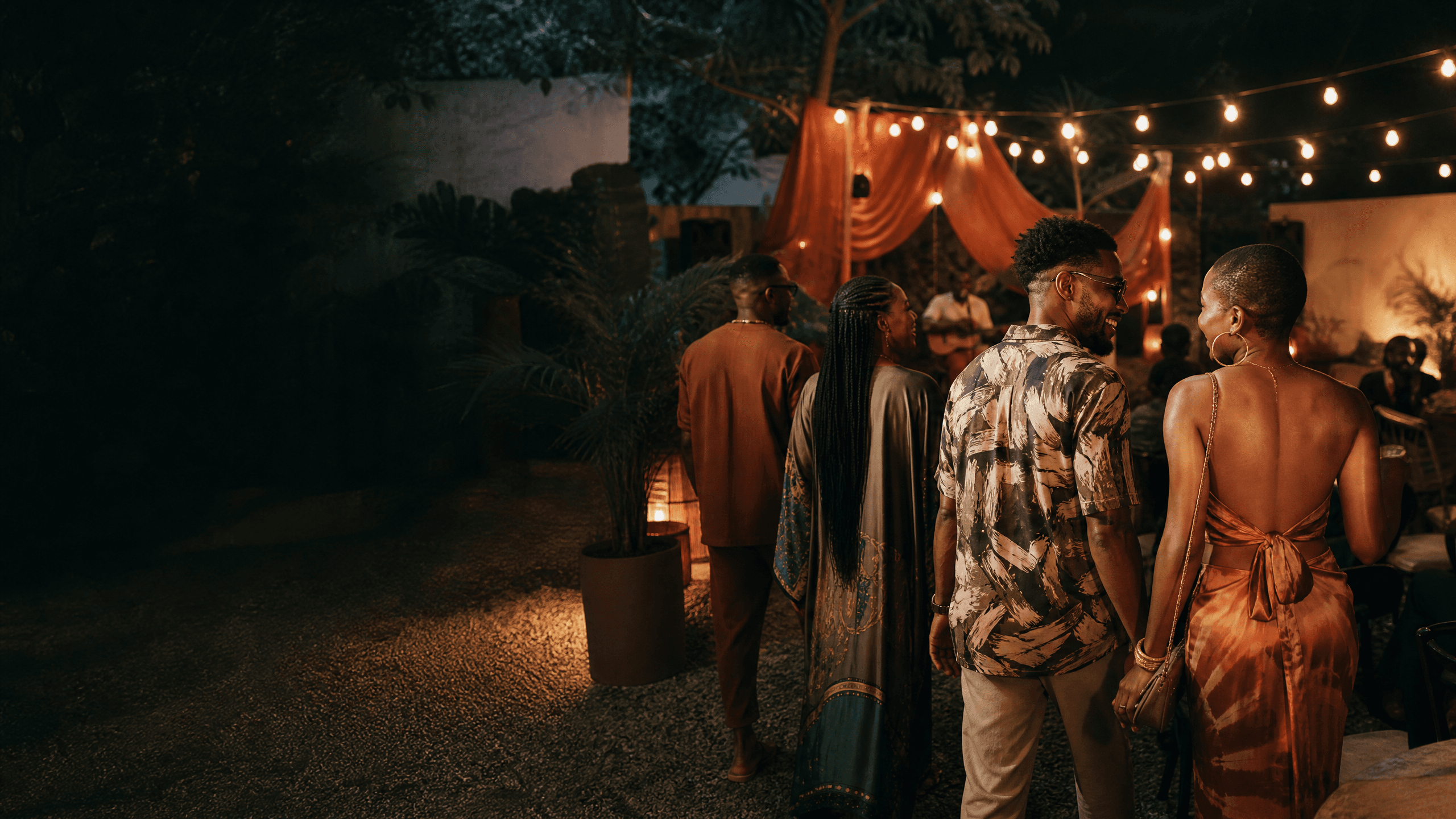 Friends arriving at an intimate Lagos creative event under warm lights